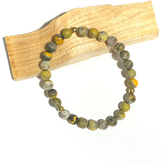 Ce bracelet en jaspe bumblebee 6mm, aux teintes jaunes et noires vibrantes, stimule la créativité, la vitalité et l'énergie positive. Une pierre idéale pour renforcer votre motivation et apporter une énergie dynamique