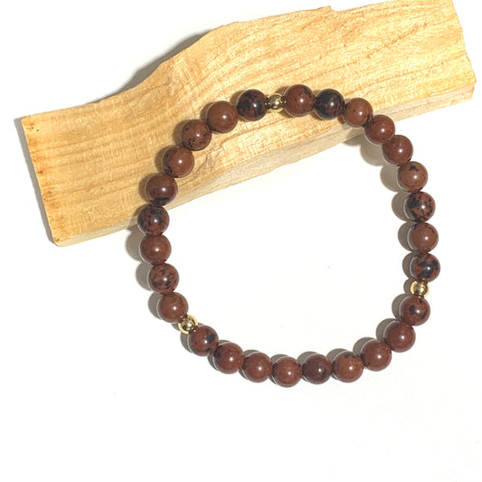 Ce bracelet en obsidienne acajou 6mm, aux teintes marron et noir, offre une puissante protection énergétique tout en favorisant l'ancrage et la clarté mentale. Une pierre idéale pour libérer les blocages et renforcer votre énergie